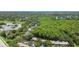 Aerial view featuring a neighborhood with abundant trees, landscaping, parking, and a glimpse of a nearby lake at 3335 Fox Hunt Dr, Palm Harbor, FL 34683