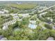 An aerial view showcases a community pool and tennis courts within a beautiful setting, perfect for recreation and relaxation at 3335 Fox Hunt Dr, Palm Harbor, FL 34683