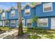 Charming blue townhome with white trim and a lush tropical landscaped yard at 3335 Fox Hunt Dr, Palm Harbor, FL 34683