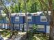 The exterior elevation of the townhome is a refreshing blue color and lush landscaping giving it great curb appeal at 3335 Fox Hunt Dr, Palm Harbor, FL 34683