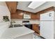 Efficient kitchen with wood cabinets, white appliances, and a bright countertop at 3335 Fox Hunt Dr, Palm Harbor, FL 34683