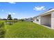 A spacious green backyard with a fence overlooking a pond in the distance at 33369 Hamilton Hill Ln, Wesley Chapel, FL 33545