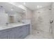 Modern bathroom features a dual-sink vanity with grey cabinets and an oversized walk-in shower with a rainfall showerhead at 33369 Hamilton Hill Ln, Wesley Chapel, FL 33545