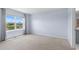 Bedroom with window, light blue walls, light-colored carpet, and window with a view of the backyard at 33369 Hamilton Hill Ln, Wesley Chapel, FL 33545