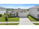 Charming single-story home with a well-maintained lawn, two-car garage, and serene lake views at 33369 Hamilton Hill Ln, Wesley Chapel, FL 33545