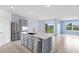 Bright kitchen boasts an island with stainless steel appliances and lots of natural light with backyard views at 33369 Hamilton Hill Ln, Wesley Chapel, FL 33545