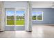 Bright living room boasts tile floors, slider patio access, and abundant natural light, and serene water views at 33369 Hamilton Hill Ln, Wesley Chapel, FL 33545