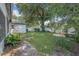 Spacious backyard with lush greenery, mature trees, and a cozy seating area at 34811 Arbor Green Pl, Zephyrhills, FL 33541