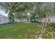 Lush backyard with mature trees, a well-manicured lawn, and a charming seating area at 34811 Arbor Green Pl, Zephyrhills, FL 33541