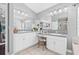 Bathroom featuring dual sinks, white cabinets, and a large mirror at 34811 Arbor Green Pl, Zephyrhills, FL 33541