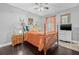 Bedroom with hardwood floors, a four poster bed, and orange accents at 34811 Arbor Green Pl, Zephyrhills, FL 33541