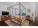 Bedroom features a four poster canopy bed, dark floors, and neutral walls at 34811 Arbor Green Pl, Zephyrhills, FL 33541