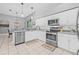 Bright and open kitchen featuring stainless steel appliances, white cabinets, and a breakfast nook area at 34811 Arbor Green Pl, Zephyrhills, FL 33541