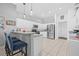 Spacious kitchen boasts modern appliances, white cabinetry, and a breakfast bar for casual dining at 34811 Arbor Green Pl, Zephyrhills, FL 33541