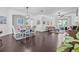 Bright and airy living room featuring dark wood floors, elegant furnishings, and sliding glass doors to the lanai at 34811 Arbor Green Pl, Zephyrhills, FL 33541