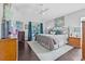 This main bedroom has dark wood floors and sliding doors to the screened lanai at 34811 Arbor Green Pl, Zephyrhills, FL 33541