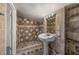 This full bathroom is equipped with decorative tiling, shower and pedestal sink at 3513 Syracuse St, Port Charlotte, FL 33952