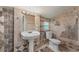 This full bathroom is equipped with decorative tiling and a pedestal sink at 3513 Syracuse St, Port Charlotte, FL 33952