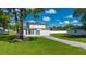 Charming two-story home with a well-manicured lawn, long driveway, and white picket fence at 3513 Syracuse St, Port Charlotte, FL 33952