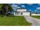 Charming two-story home with a well-manicured lawn and mature landscaping and a large driveway at 3513 Syracuse St, Port Charlotte, FL 33952