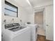 Bright laundry room includes a washer, dryer, and a window at 3513 Syracuse St, Port Charlotte, FL 33952