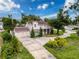 Lovely home showcasing a sprawling driveway, lush trees, and an attached two-car garage at 425 49Th N St, St Petersburg, FL 33710