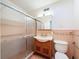 Bathroom has tile floors, a wood vanity, a vintage sink and a glass-door shower at 425 49Th N St, St Petersburg, FL 33710