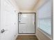 Bright bathroom showing new glass-enclosed shower, light walls, a window, and neutral toned flooring at 425 49Th N St, St Petersburg, FL 33710