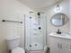 Updated bathroom with a corner shower unit, modern vanity, and round mirror, creating a sleek and functional space at 425 49Th N St, St Petersburg, FL 33710