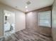 Bedroom featuring gray wood-look tile flooring and an ensuite bathroom with a tiled wall detail and window at 425 49Th N St, St Petersburg, FL 33710