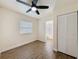 Bedroom with wood-look floors, ceiling fan, closet, and a view to an ensuite bathroom at 425 49Th N St, St Petersburg, FL 33710
