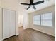 Bedroom featuring wood-look floors, a ceiling fan, a closet, and a view to an ensuite bathroom at 425 49Th N St, St Petersburg, FL 33710