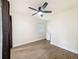 Bright bedroom with a ceiling fan, a mini refrigerator, wood-look floors, and natural light through a window at 425 49Th N St, St Petersburg, FL 33710