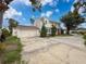 Attractive two-story home with an attached two-car garage, green shrubs, and a long driveway at 425 49Th N St, St Petersburg, FL 33710