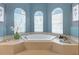 Bathroom featuring a soaking tub surrounded by three windows, and ocean themed decor at 4428 Gevalia Dr, Brooksville, FL 34604