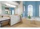 Bathroom features vanity with make up table and soaking tub under arched window at 4428 Gevalia Dr, Brooksville, FL 34604