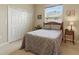 Comfortable bedroom with queen-sized bed, soft carpet, and a large window with blinds at 4428 Gevalia Dr, Brooksville, FL 34604