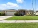 Beautiful single-story home with arched windows, a well-manicured lawn, and a spacious driveway at 4428 Gevalia Dr, Brooksville, FL 34604