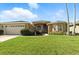 Beautiful single-story home with arched windows, a well-manicured lawn, and a spacious driveway at 4428 Gevalia Dr, Brooksville, FL 34604