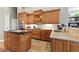 Modern kitchen featuring wood cabinets, stainless steel appliances, and a granite island for meal preparation and entertaining at 4428 Gevalia Dr, Brooksville, FL 34604