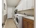 Well-organized laundry room featuring modern washer and dryer, storage cabinets, and a utility sink at 4428 Gevalia Dr, Brooksville, FL 34604