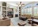 Spacious living room with fireplace, built-in shelving, large windows, ceiling fan, and comfortable seating at 4428 Gevalia Dr, Brooksville, FL 34604