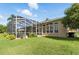 Backyard view of the screened-in lanai with pool and spa and well maintained landscaping at 4428 Gevalia Dr, Brooksville, FL 34604