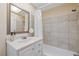 Bathroom featuring white vanity with framed mirror and tiled shower/tub combination at 4915 Stolls Ave, Tampa, FL 33615