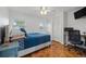 Well-lit bedroom with a comfy bed, hardwood floors, and a modern desk setup, ideal for relaxation and work at 4915 Stolls Ave, Tampa, FL 33615