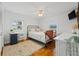 Bright bedroom featuring hardwood floors, a wrought iron bed frame, and a well-lit study area at 4915 Stolls Ave, Tampa, FL 33615