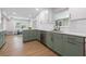 Modern kitchen with a large island, white countertops, green cabinets, and stainless steel appliances at 4915 Stolls Ave, Tampa, FL 33615