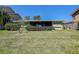 Expansive backyard with green lawn, mature bushes, and a screened patio at 501 Crystal Dr, Madeira Beach, FL 33708