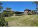 Large grassy backyard with mature tropical landscaping and screened patio at 501 Crystal Dr, Madeira Beach, FL 33708