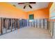 Unfinished bedroom featuring bright orange walls, a ceiling fan, and a window overlooking the outdoors at 501 Crystal Dr, Madeira Beach, FL 33708